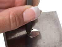 Stamping metal blank on a steel block